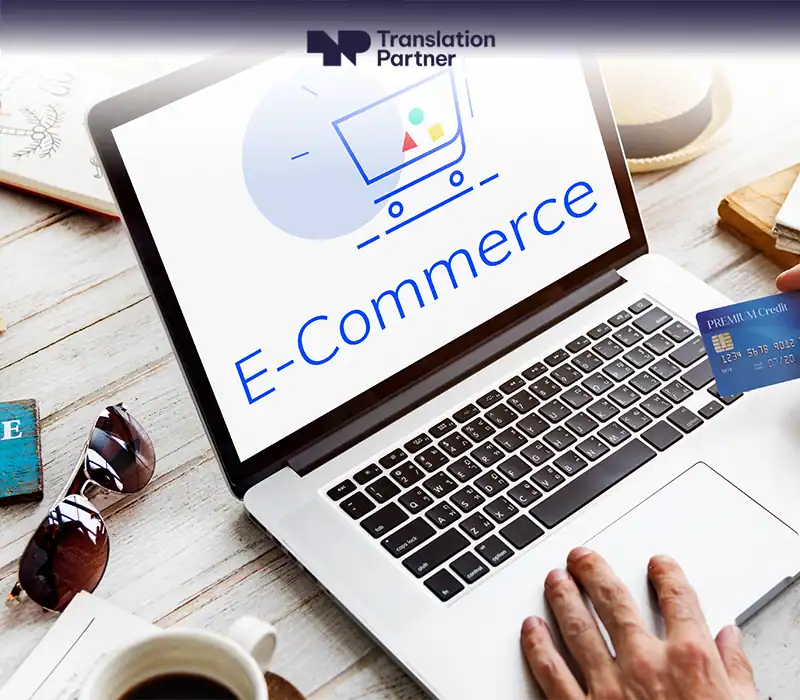 Person using a laptop to make an online purchase with a credit card; "E-Commerce" and "Translation Partner" shown