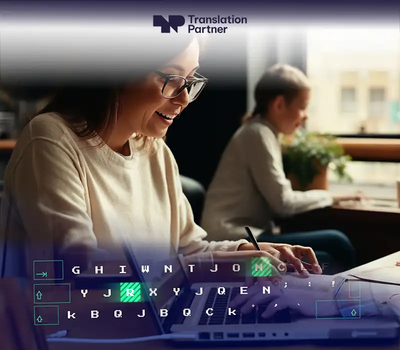Woman typing on laptop with keyboard overlay and Translation Partner logo.